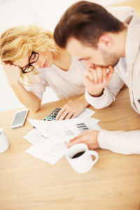 A picture of a worried couple with documents at home